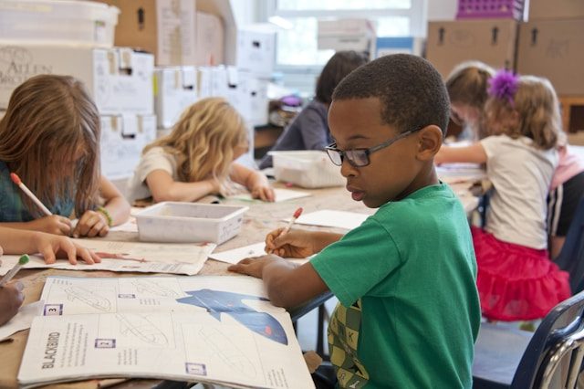 Young children reading and working on schoolwork in a classroom