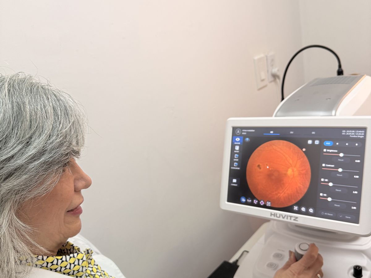 Dr. Roxanna Gangi reviewing a fundus retinal image at the imaging device — pre-operative cataract assessment and ocular health evaluation before cataract surgery referral in York Region