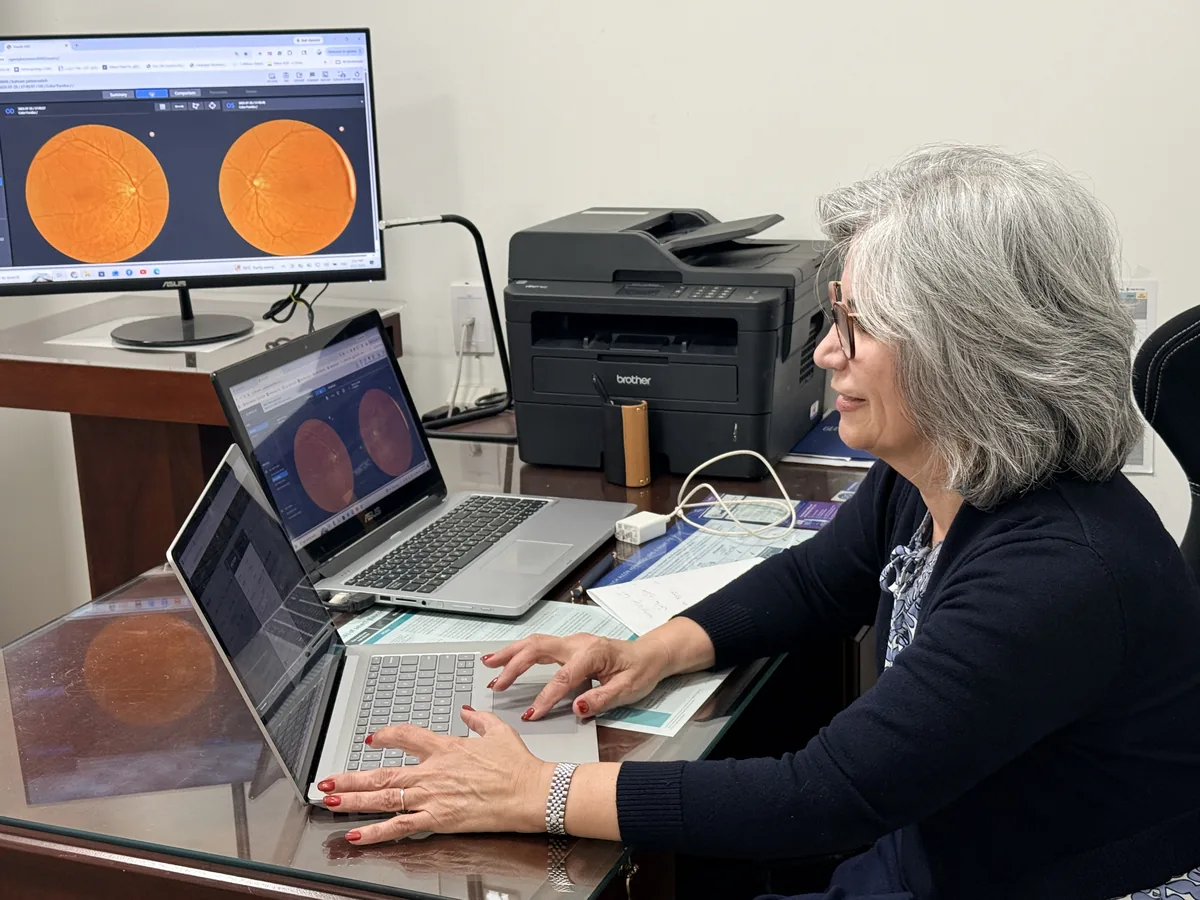 Dr. Roxanna Gangi reviewing colour retinal photographs on screen during a diabetic eye exam in York Region