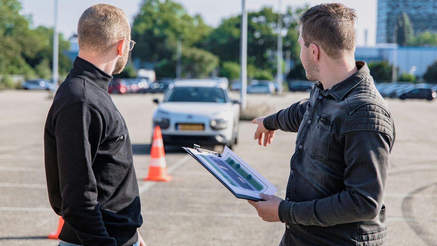 Driving instructor reviewing a road test plan with a student in a parking lot — visual field and MTO driver's license vision testing with Dr. Roxanna Gangi at Pro Eye Exam in York Region
