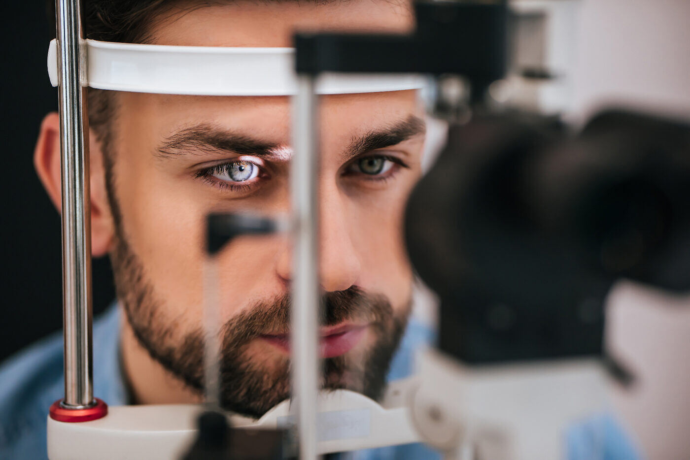 Adult male patient seated at a slit lamp biomicroscope during an intraocular pressure check and optic nerve evaluation — glaucoma co-management and surgical referral coordination with Dr. Roxanna Gangi at Pro Eye Exam in York Region