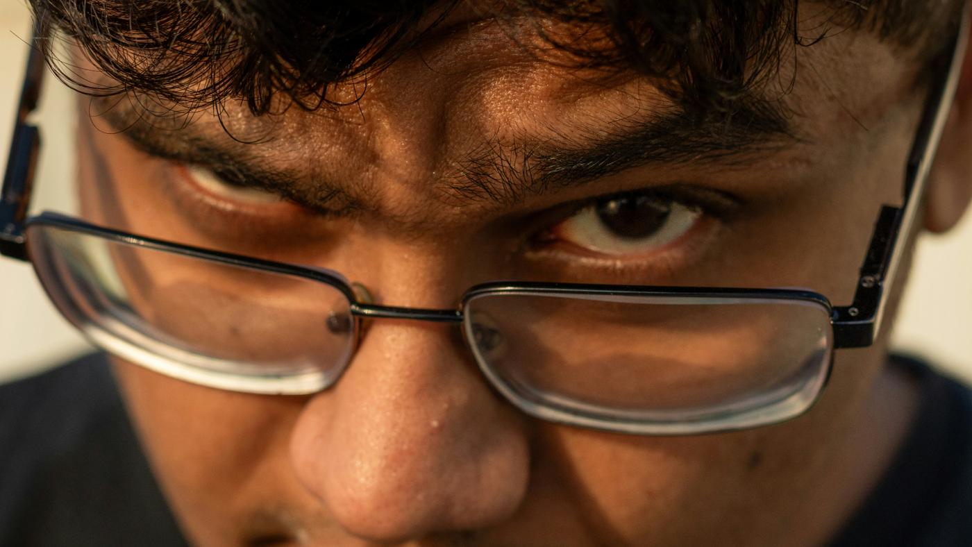 Close-up of a man peering over his prescription glasses — refractive error and glasses dependence patients consider PRK laser vision correction with Dr. Roxanna Gangi in York Region