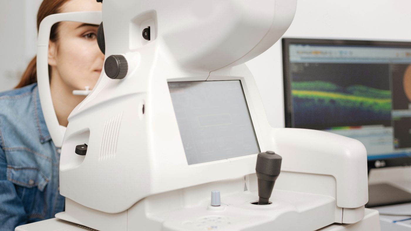 Patient undergoing OCT retinal imaging scan with cross-sectional macular scan displayed on screen — advanced retinal pathology assessment at Pro Eye Exam in York Region