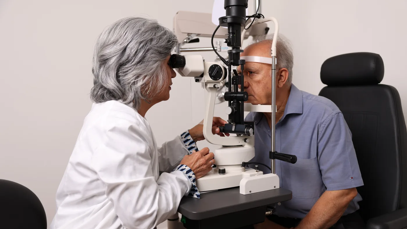 Dr. Roxanna Gangi examining a senior patient at the slit lamp during a senior eye exam in York Region