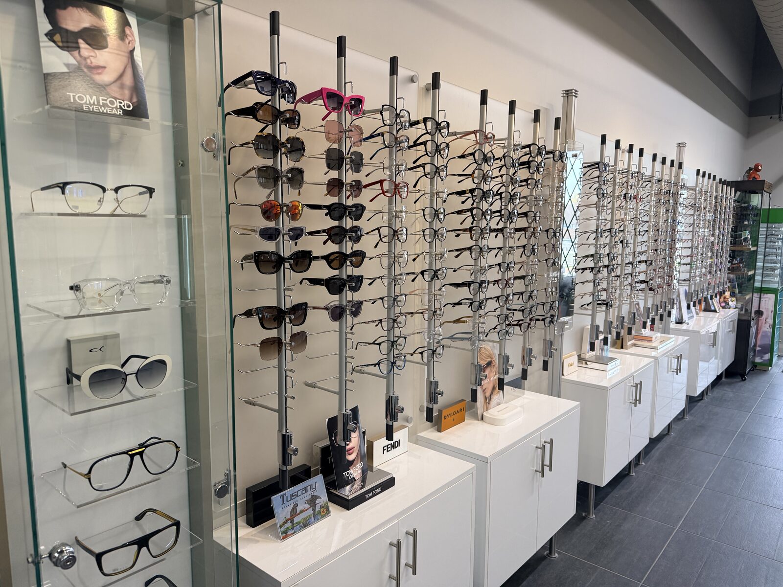 Inside Temkin Opticians in Vaughan — designer eyewear and sunglasses wall featuring Tom Ford, Fendi, Bvlgari, and other premium frames, with prescription glasses fittings available alongside Dr. Roxanna Gangi's eye exams.